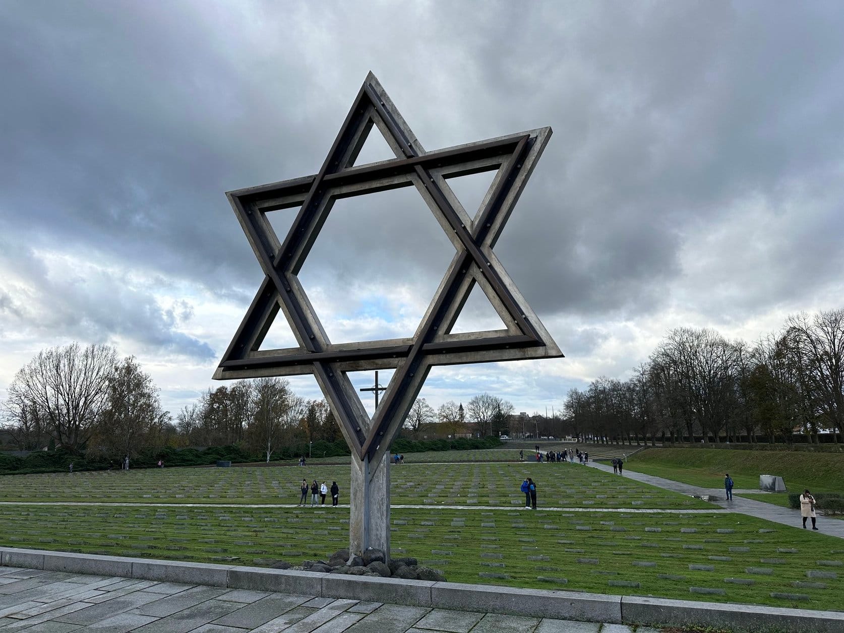 An image of a large star of David overlooking a cemetery.